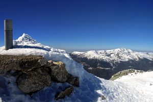 Vértice Geodésico de Cabeza de Hierro Mayor (2382 m). Peñalara al fondo.